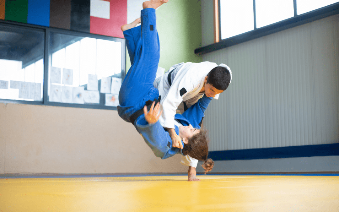 Dos judokas compitiendo en un combate, ejecutando técnicas de lanzamiento en el tatami.